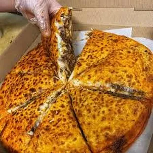 a hand grabbing a slice of pizza