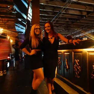 two women standing in front of a bar