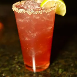 a closeup of a drink with a slice of lemon on the rim