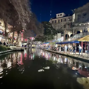 Riverwalk on the river by the restaurant center of the photo.