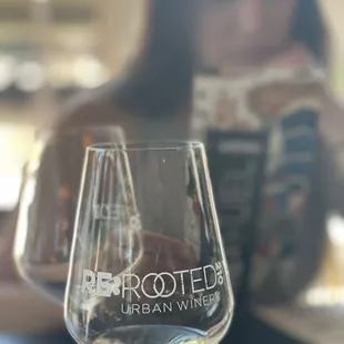 a woman sitting at a table with a glass of wine
