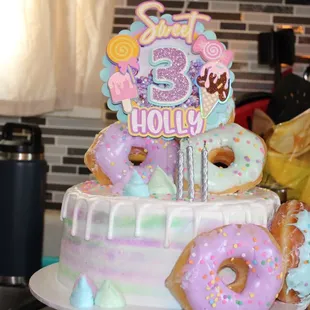 a birthday cake with frosting and donuts
