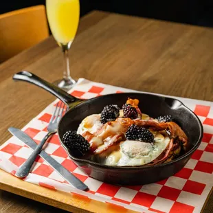a bowl of breakfast food on a table with a glass of orange juice