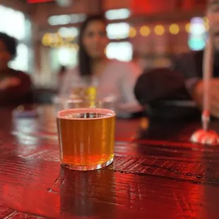 a glass of beer on a bar