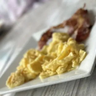a plate of scrambled eggs and bacon