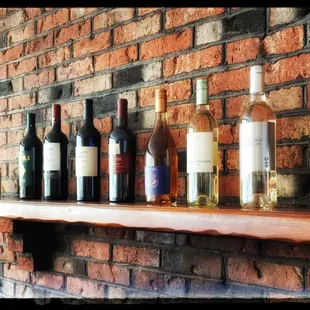bottles of wine lined up on a shelf
