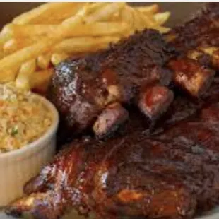 a plate of ribs, fries, and coleslaw