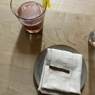 a glass of wine and a napkin on a wooden table