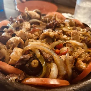 Mixed meat clay pot meal with onions mushrooms bacon etc