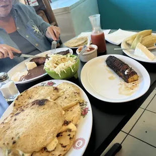 Plate of papusas, plantain, corn tamales, curtido, salsas, Mom with her breakfast plate of steak, eggs, beans, and plantain with tortillas