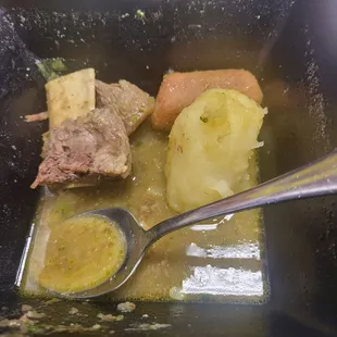a bowl of soup with meat and potatoes