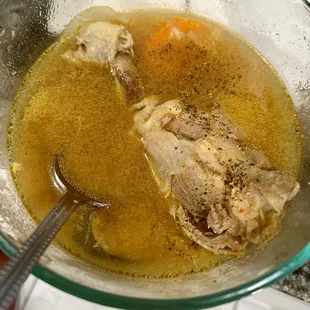 Chicken soup with bone. Black pepper added by diner. Sopa de pollo para llevar, con hueso de pollo. El comensal le añadió pimienta negra.