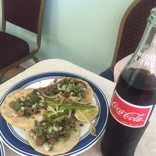 two plates of food and a bottle of coke