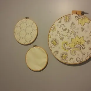 two embroiderys on a wall