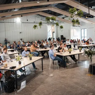 a room full of people sitting at tables