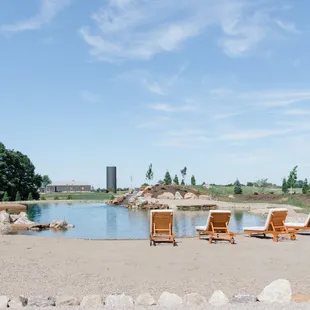 a view of a pond and lawn chairs