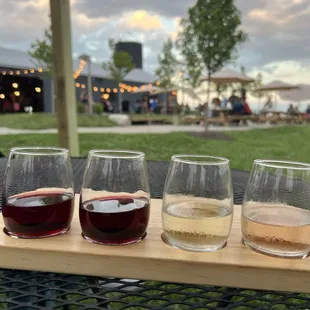 four glasses of wine on a wooden tray