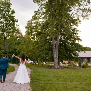 a bride and groom walking down a path