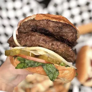 a hand holding a hamburger