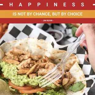 a hand holding a fork and eating a taco