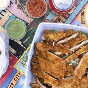 a plate of fried chicken strips and a can of beer