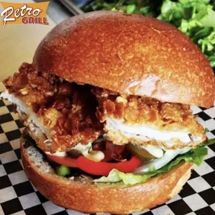 a chicken sandwich with lettuce and tomatoes