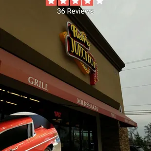 a red car parked in front of a restaurant