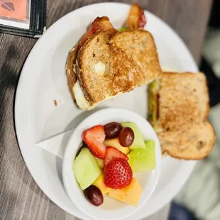 a plate of fruit and sandwich