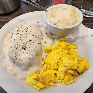 a plate of food with eggs, mashed potatoes, and gravy