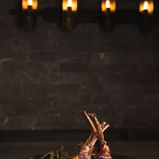 a plate of lamb chops on a bed of mashed potatoes