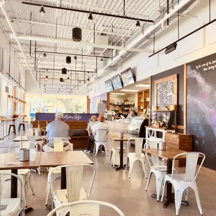 the interior of a restaurant with tables and chairs