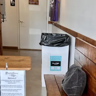 a wooden bench and a trash can