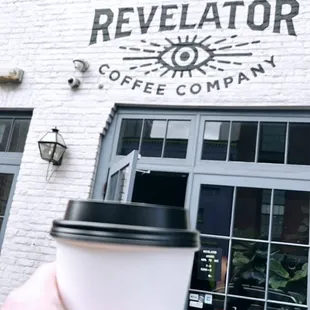 a hand holding a cup of coffee