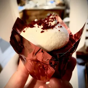 a hand holding a piece of cake