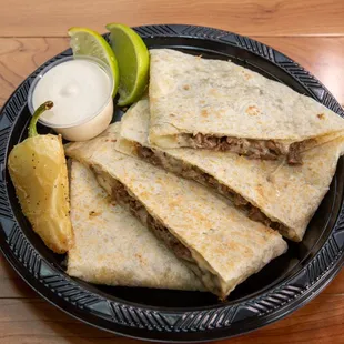 a plate of quesadillas with lime wedges