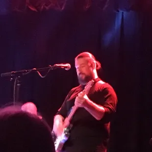 a man playing a guitar on stage