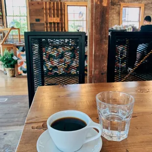 a cup of coffee on a wooden table