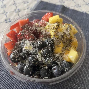 Build your own açaí bowl with strawberries, mango, blueberries, chia seeds, and coconut drizzled with honey