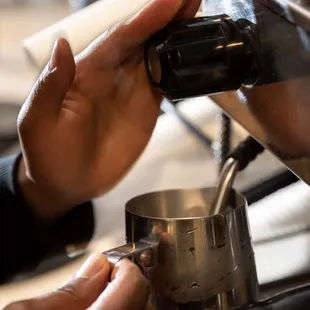 a person preparing a cup of coffee