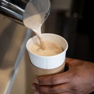 a person pouring coffee into a cup