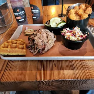 Pulled pork, seasoned tots, slaw, and pickles. In the back are the two sauces.