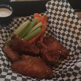 a basket of chicken wings and carrots
