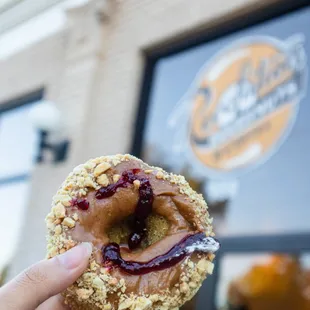 a hand holding up a doughnut