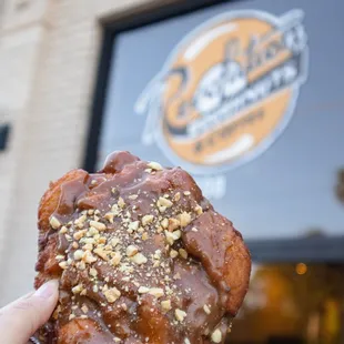 a hand holding a doughnut