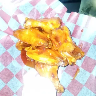 a plate of chicken wings on a checkered table cloth