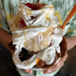 a child holding an ice cream sundae