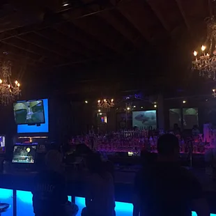 Chandeliers and stripper poles in the same bar.