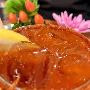 a glass of iced tea with a lemon wedge