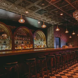 a dimly lit bar with a checkered floor