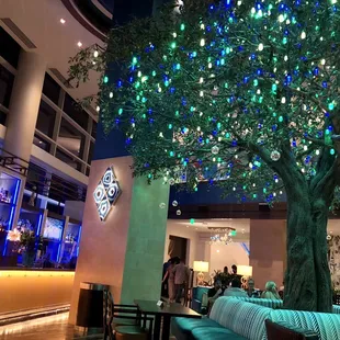 a large tree in a restaurant with blue lights